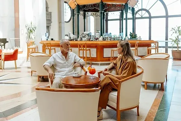 Paar genießt Cocktails bei R2 Hoteles: Corporativa, Meerblick.