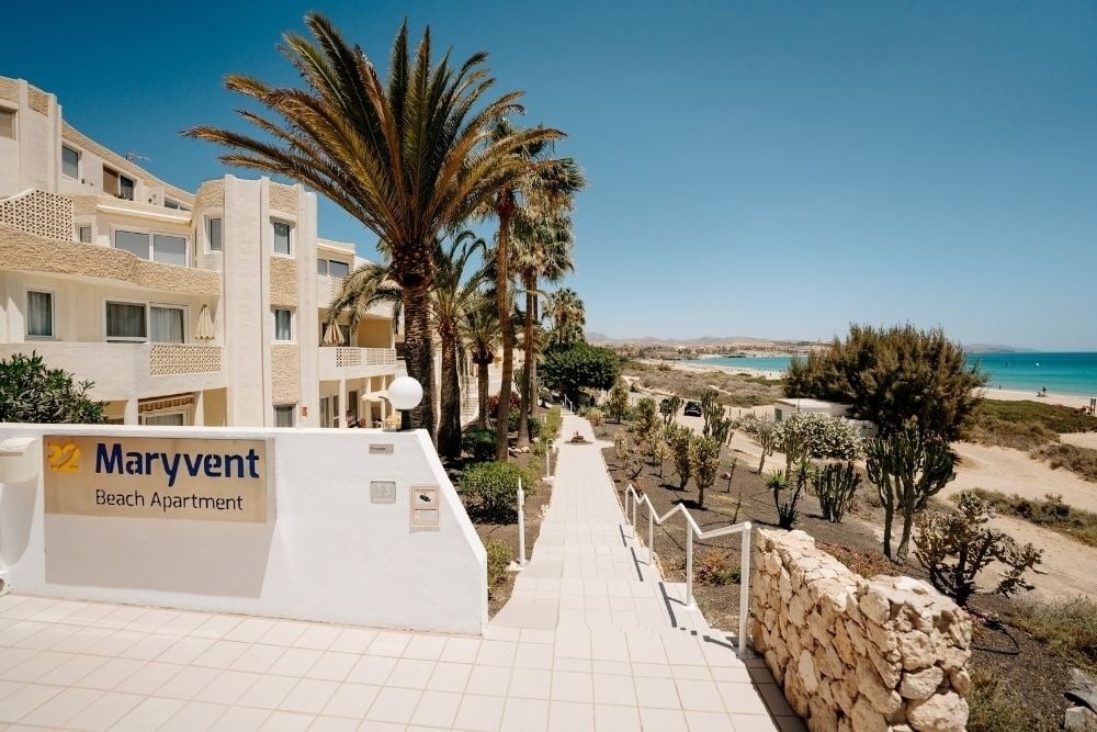 R2 Maryvent Beach Apartment: Beachfront building with palm trees and sea views.