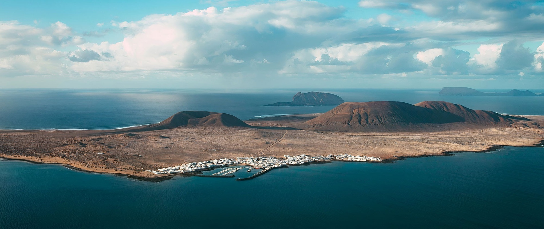 una piscina rodeada de sillas y sombrillas con vistas al océano