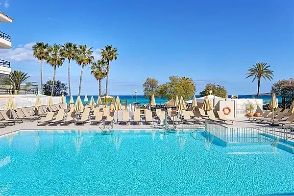 R2 Hoteles: Corporativa - Piscina y hotel Verónica Beach con tumbonas y sombrillas.