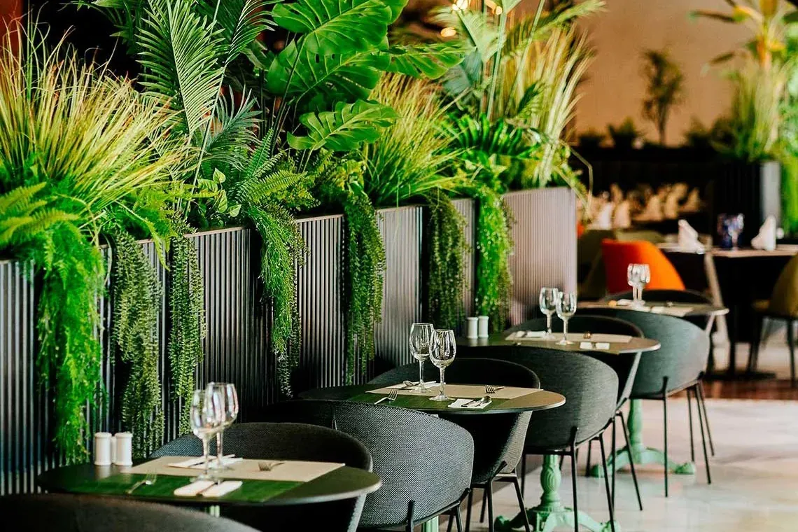 Sala da pranzo aziendale R2 Hotels: Lussureggiante vegetazione interna ed eleganti tavoli.