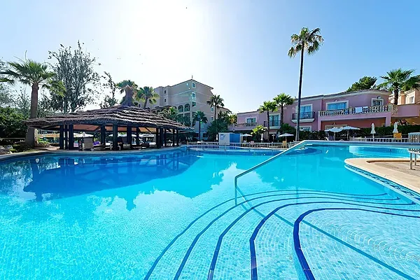 R2 Hoteles: Corporativa. Piscina con bar y tumbonas bajo palmeras.