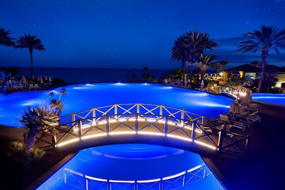 Beleuchtete Brücke über blauem Pool im R2 Río Calma Hotel Fuerteventura