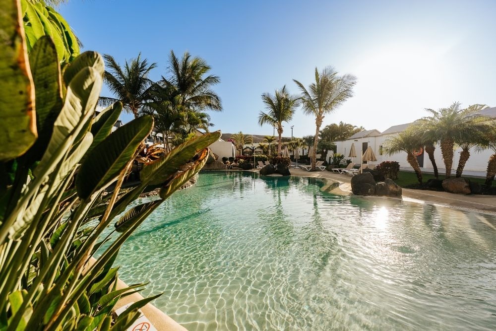 Ein Tisch mit Tellern und Besteck und einer Tischdecke mit Fischen und Wellen.