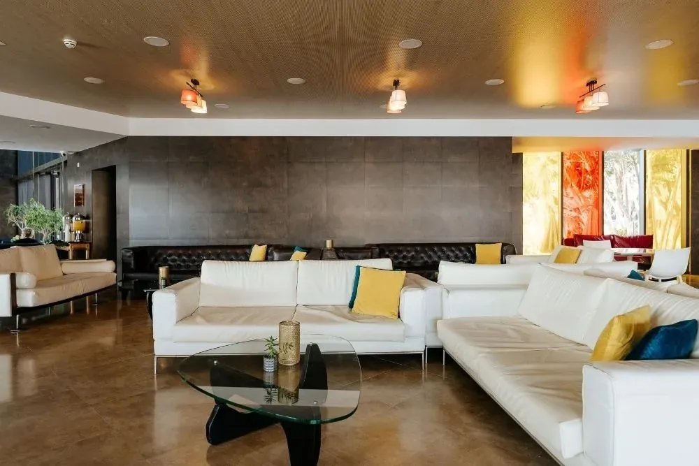 Lobby R2 Hoteles Corporativa: sofás blancos, mesa de cristal, decoración moderna.