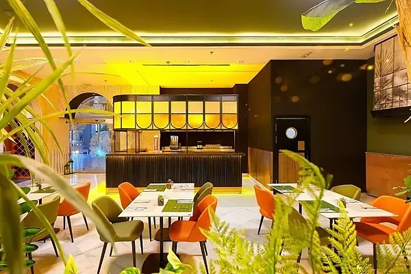 R2 Hotels: Modernes Restaurant mit grünen und orangen Stühlen.