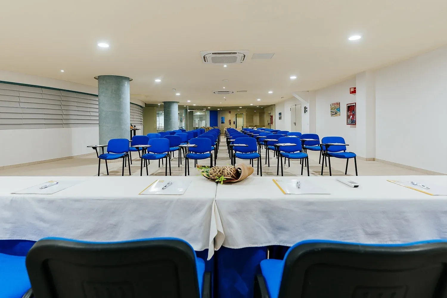 R2 Hotels Konferenzraum: Blaue Stühle, Tische für Firmenveranstaltungen.