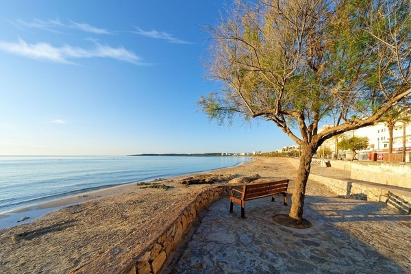 ein Tisch mit Tellern und Besteck und einer Tischdecke mit Fischen und Wellen