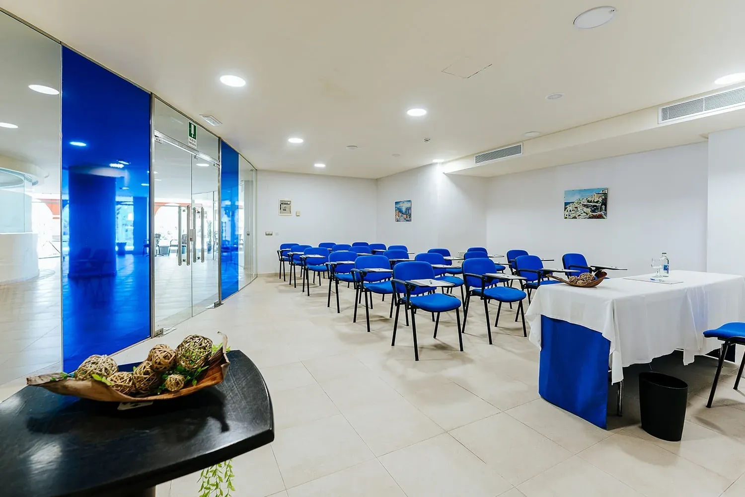 R2 Hotels: moderner Konferenzraum für Unternehmen mit blauen Stühlen.