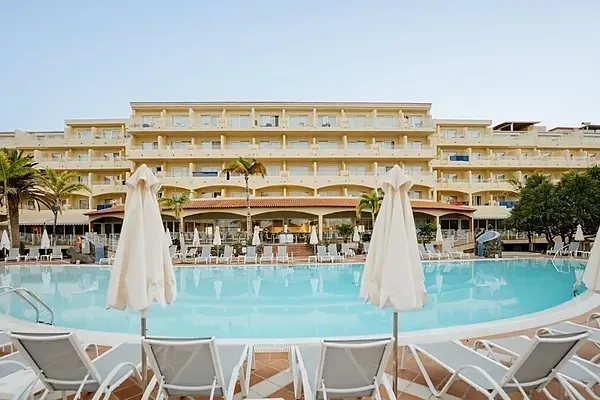 R2 Hoteles: Piscina y palmeras con tumbonas, ideal para vacaciones.