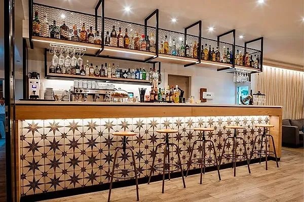Moderne Bar im R2 Hoteles: Corporativa mit Spirituosenregalen und Hockern.
