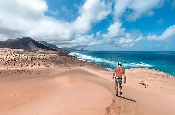 Viajero en dunas con vista al océano. R2 Hoteles: Corporativa.