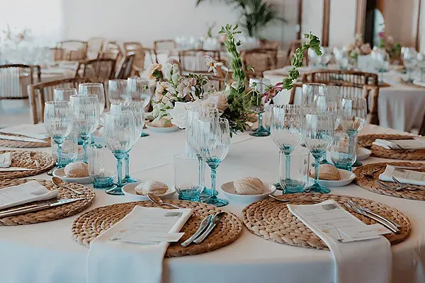 R2 Hoteles: Luxuriöser Bankett-Tisch mit blauen Gläsern und Blumenarrangements.