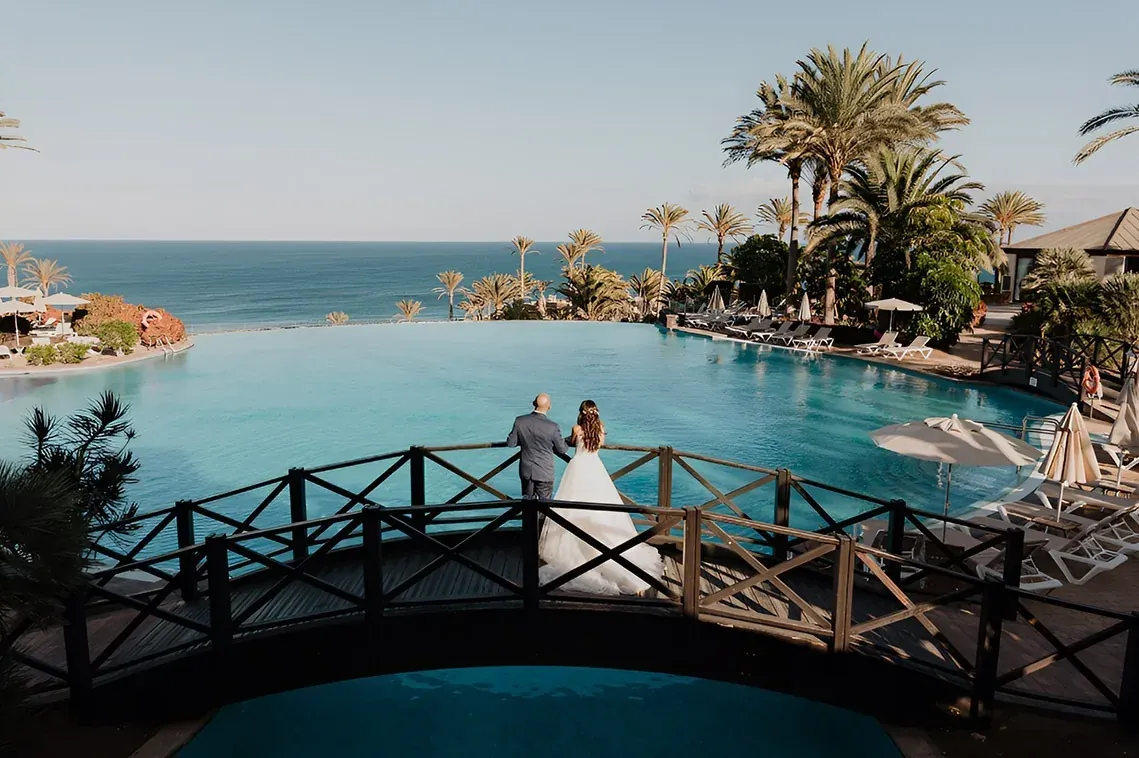 R2 Hoteles: Corporativa - Novios en puente, piscina infinita con vistas al océano.