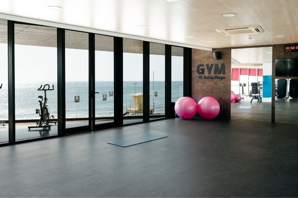 Fitnessraum im R2 Bahia Playa Design Hotel & Spa mit Meerblick und Sportgeräten.