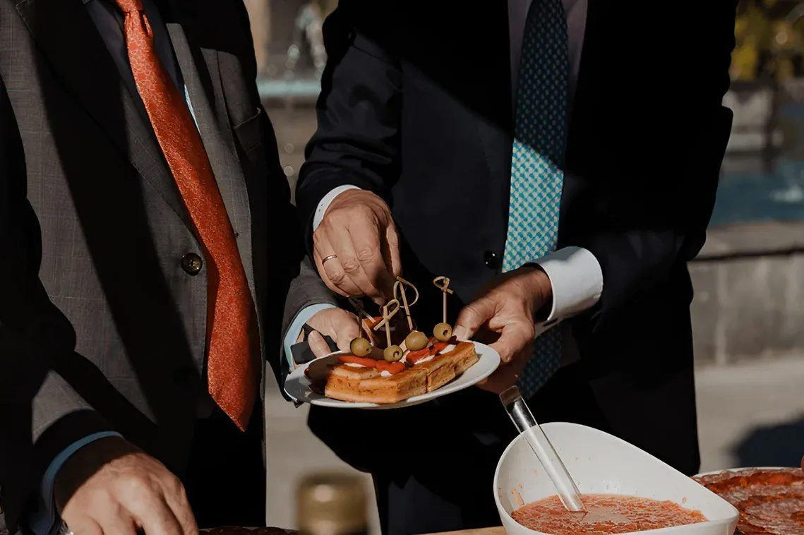 R2 Hoteles: Evento Corporativo - Hombres en traje disfrutan aperitivos.