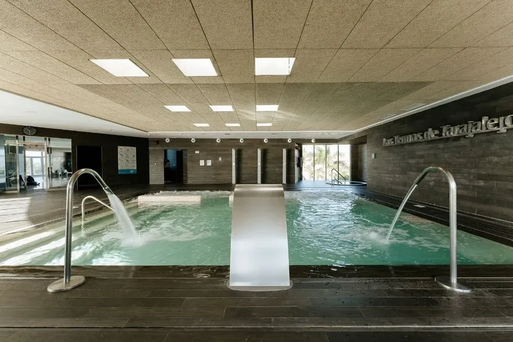 R2 Hoteles: Piscina climatizada con fuentes y diseño moderno para tu bienestar.