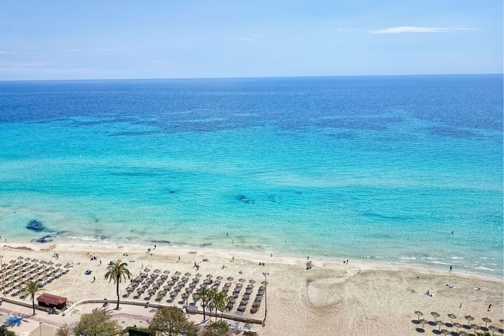 a white chair sits next to a tall white table
