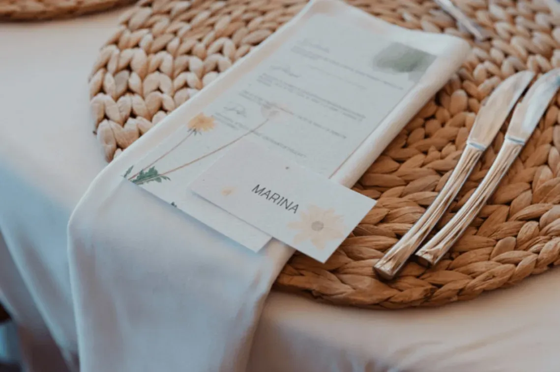 R2 Hoteles: Elegante montaje de mesa para evento corporativo con menú floral y nombre 'Marina'.