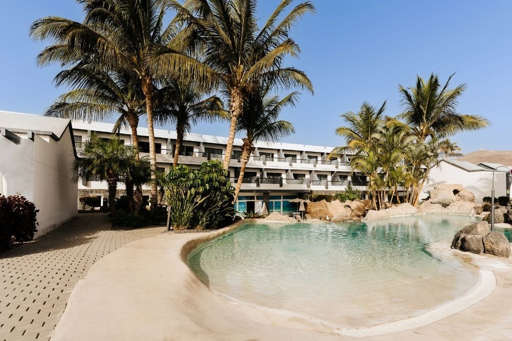 Ein Tisch mit Tellern und Besteck und einer Tischdecke mit Fischen und Wellen.