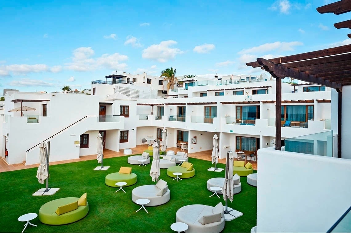 R2 Bahía Kontiki: Relájate en el patio verde con cómodos asientos y el sol de Fuerteventura.