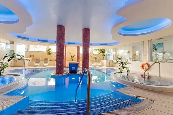 R2 Hoteles: Corporativo - Relajante piscina cubierta con jacuzzi y cascada, ideal para eventos corporativos.