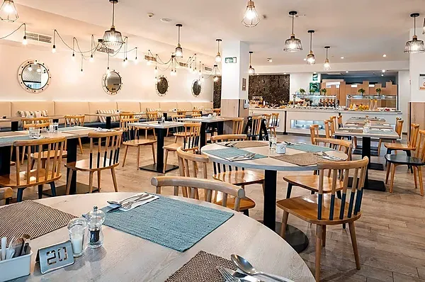 R2 Hotels: Eleganter Speisesaal mit gedeckten Tischen für Service.