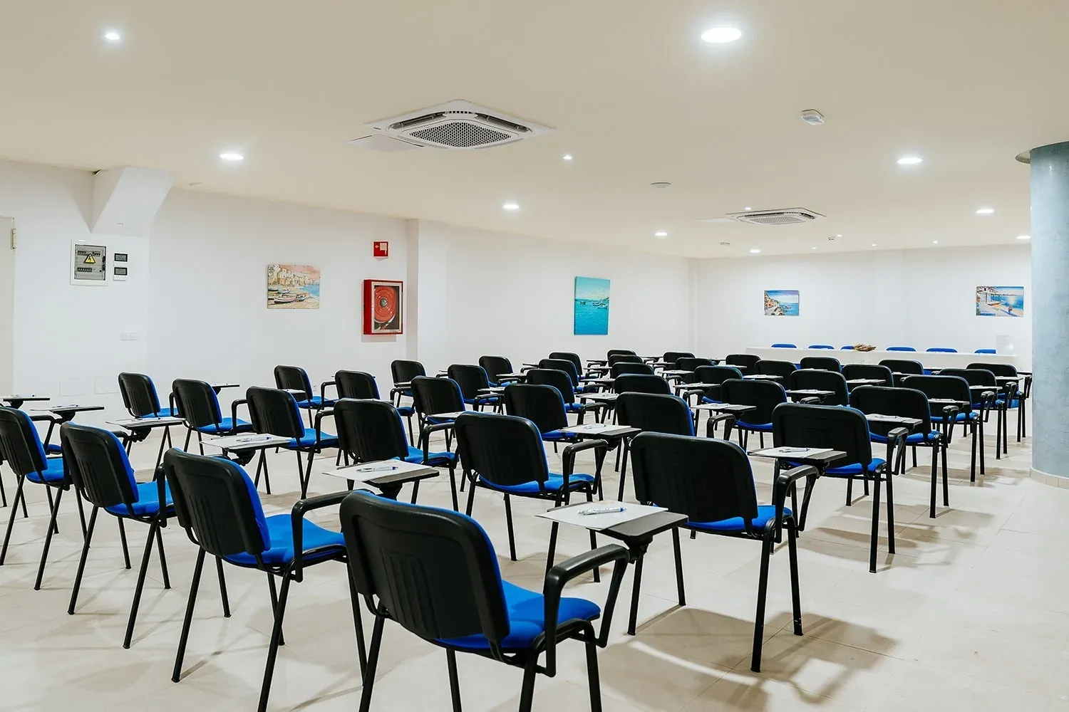R2 Hotels Konferenzraum: blaue Stühle und Tische für Firmenveranstaltungen.