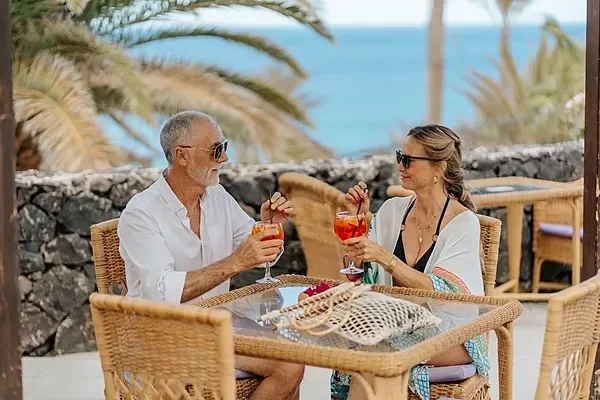 Paar genießt Cocktails bei R2 Hoteles: Corporativa, Meerblick.