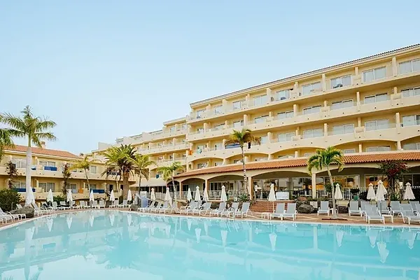R2 Hoteles: Piscina y palmeras con tumbonas, ideal para vacaciones.
