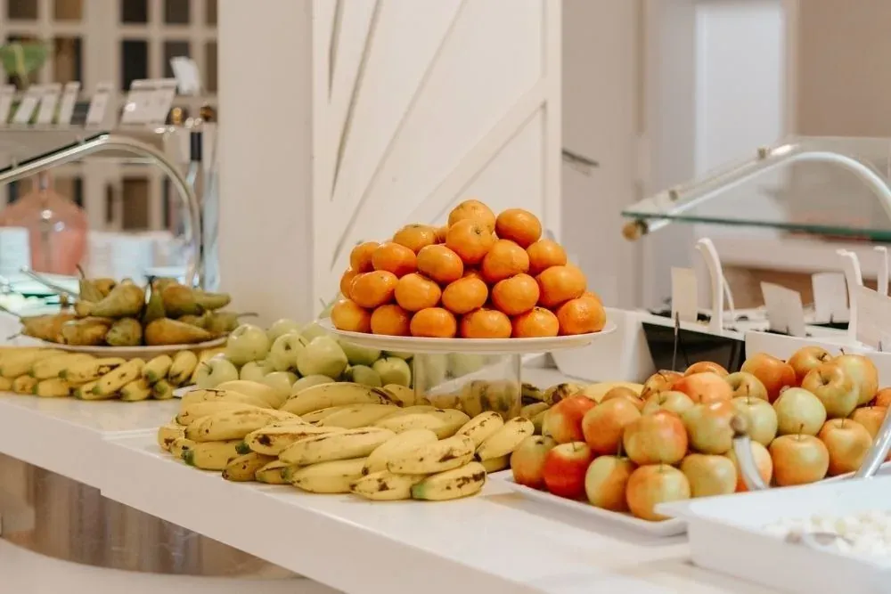 R2 Hoteles: Buffet de frutas frescas: naranjas, manzanas, plátanos y peras.