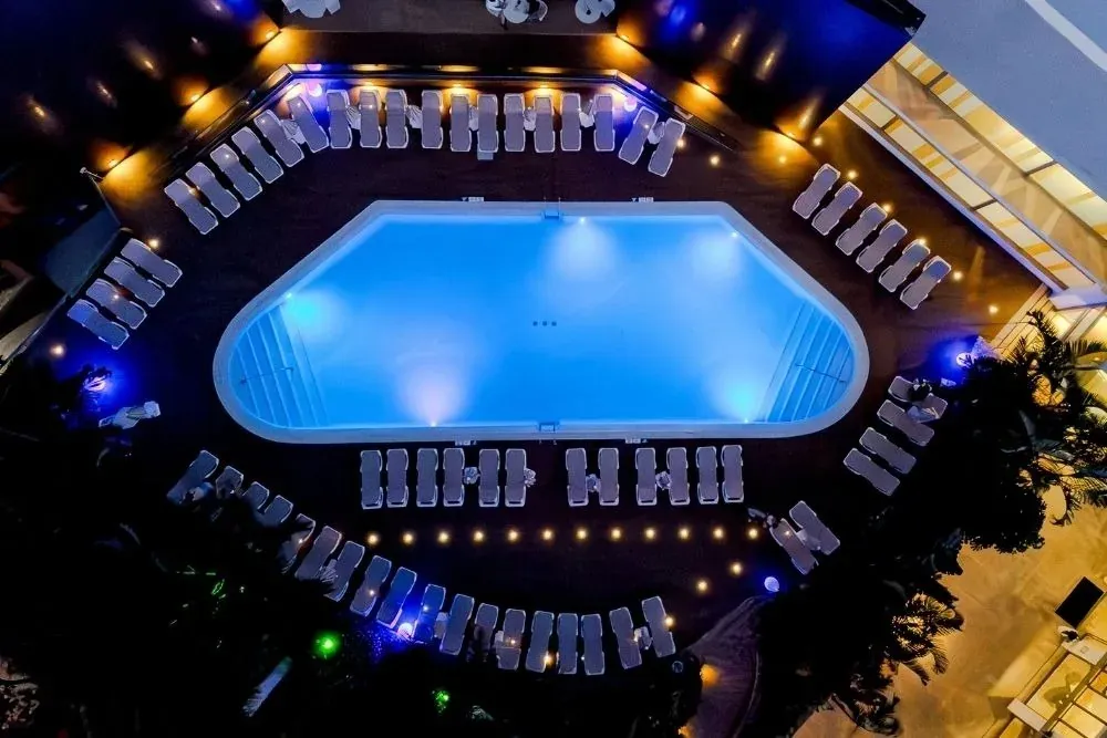 R2 Hoteles: Piscina nocturna iluminada, tumbonas, ambiente de lujo.