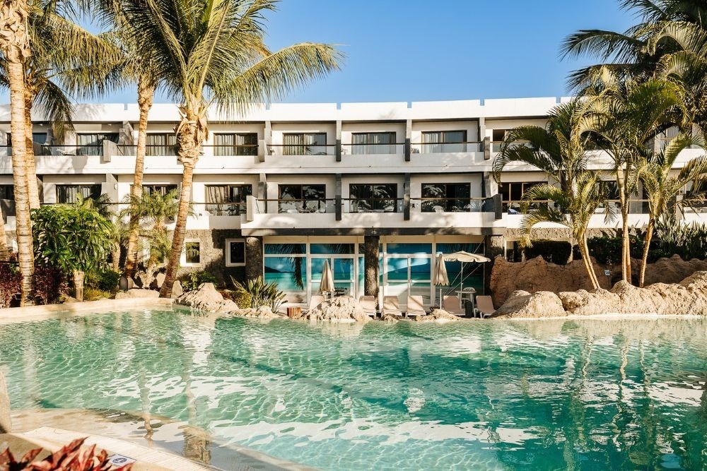 Sparkling pool and palm trees at R2 Romantic Fantasia Dreams & Suites Hotel