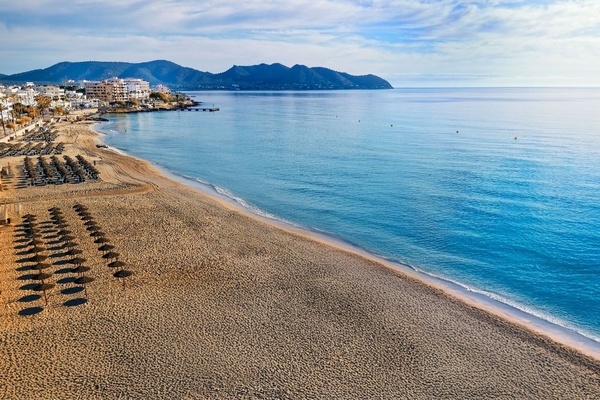 ein Tisch mit Tellern und Besteck und einer Tischdecke mit Fischen und Wellen