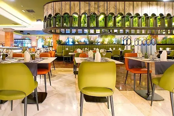 R2 Hotels: Modernes Restaurant mit grünen und orangen Stühlen.