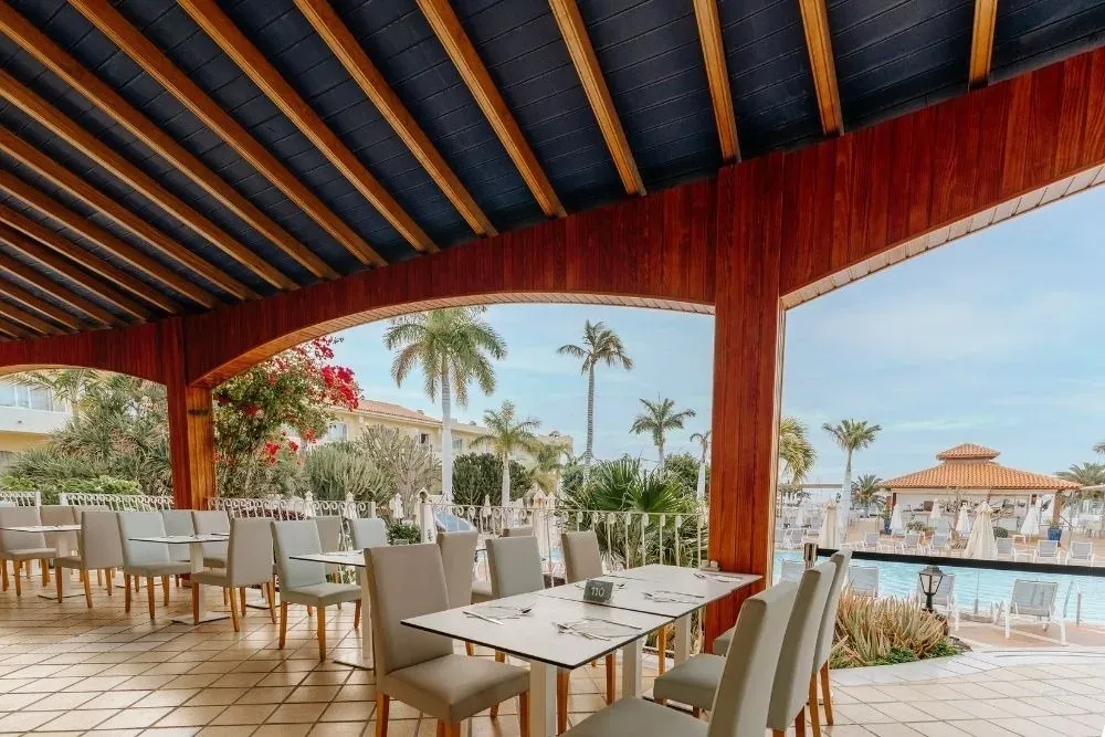 R2 Hoteles: Espacio exterior para eventos con mesas y vistas tropicales.