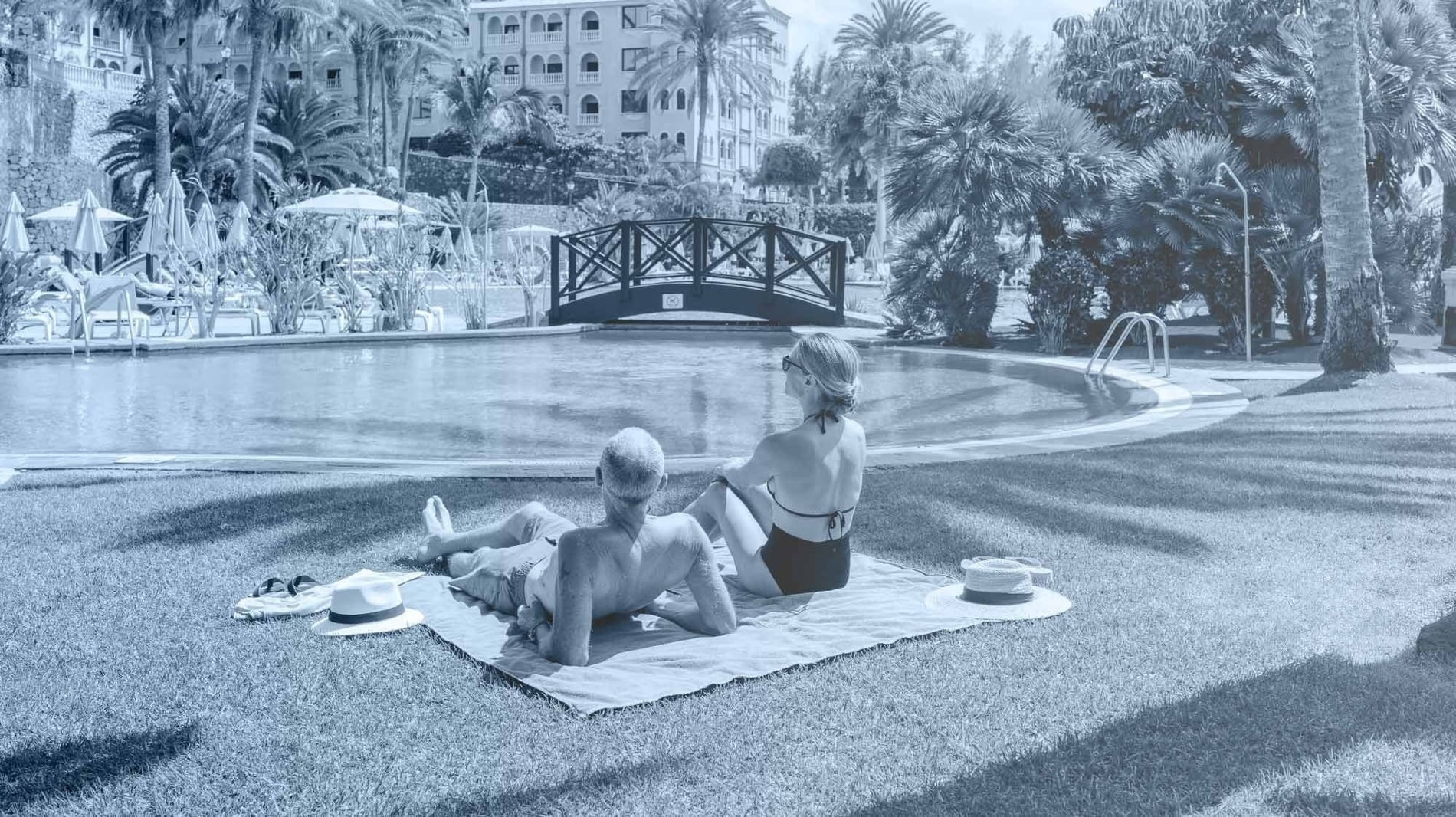 una piscina rodeada de sillas y sombrillas con vistas al océano