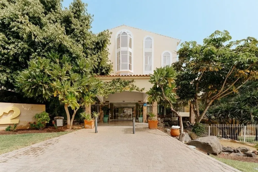 Entrada principal R2 Buganvilla Hotel & Spa: camino empedrado y vegetación exuberante.