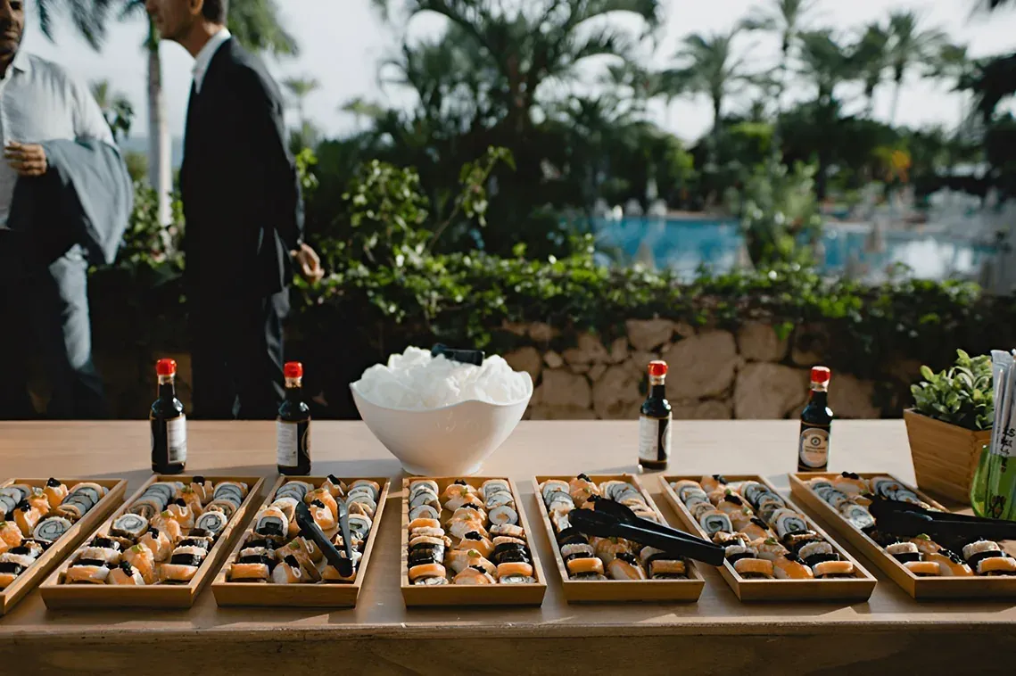 R2 Hoteles: Buffet de sushi corporativo al aire libre con piscina.