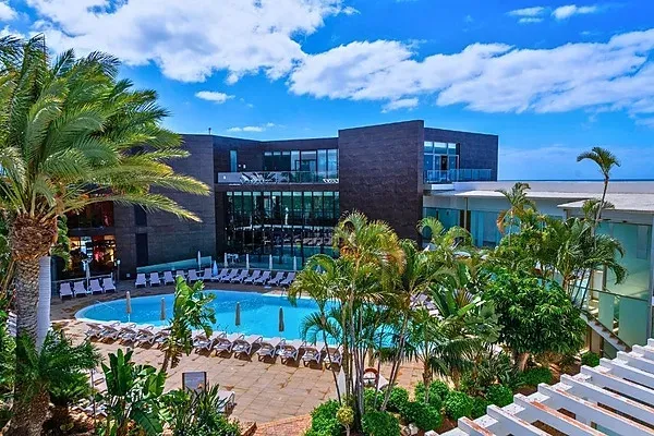 R2 Hoteles: Piscina exterior con tumbonas y vegetación tropical.