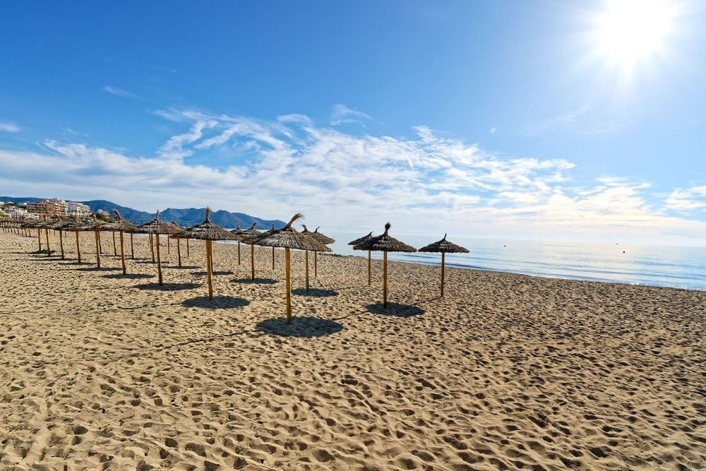 a white chair sits next to a tall white table
