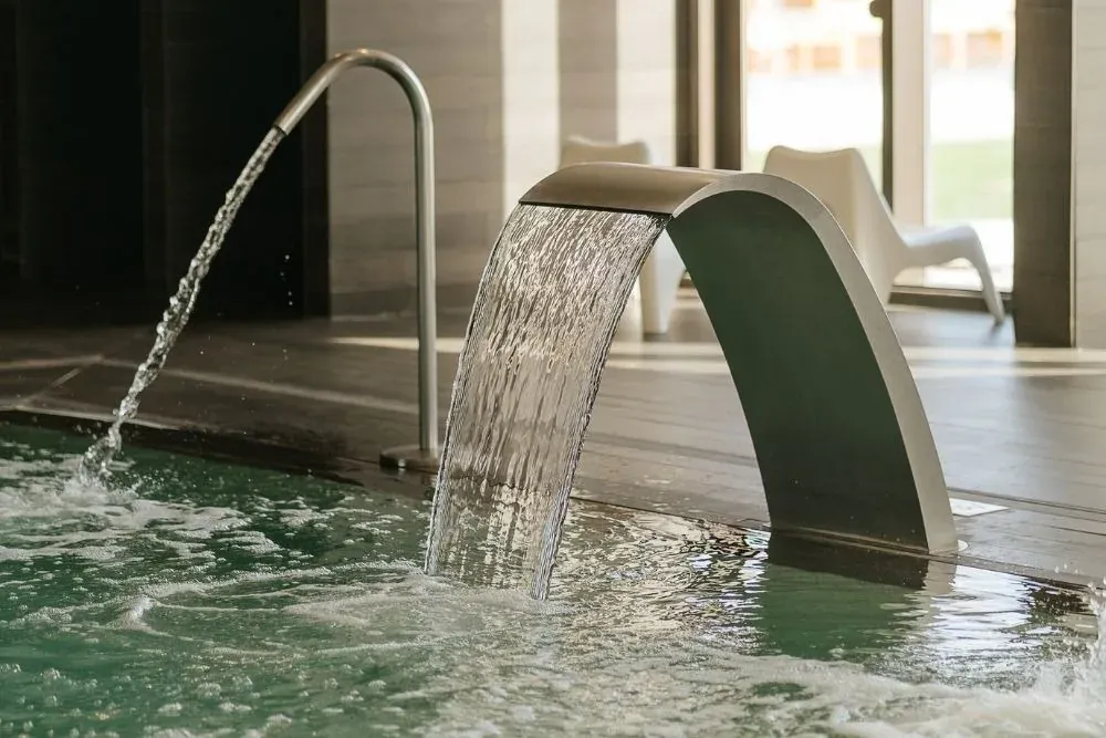 R2 Hoteles: Corporativo | Moderna fuente de agua interior para una experiencia relajante.