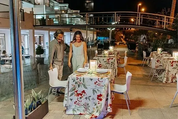 R2 Hoteles: Cena romántica al aire libre, ambiente íntimo y mesas decoradas.