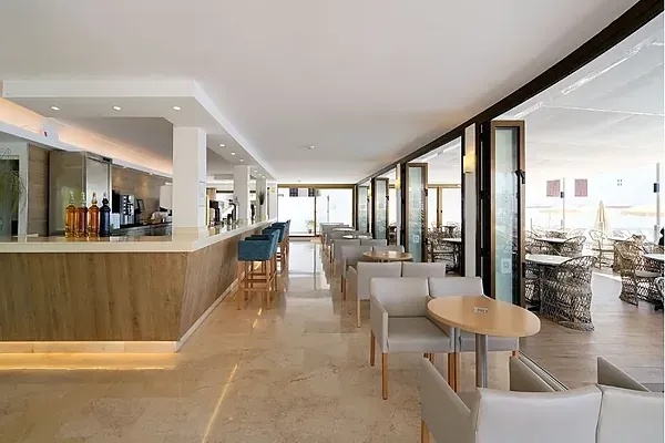 R2 Hoteles Corporativa: Bar moderno con asientos azules y ambiente elegante.