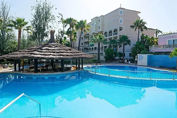 R2 Hoteles: Corporativa. Piscina con bar y tumbonas bajo palmeras.