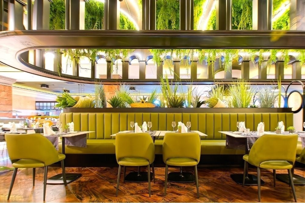 R2 Río Calma Hotel: Moderner Essbereich mit grünen Sitzplätzen und hängenden Pflanzen.