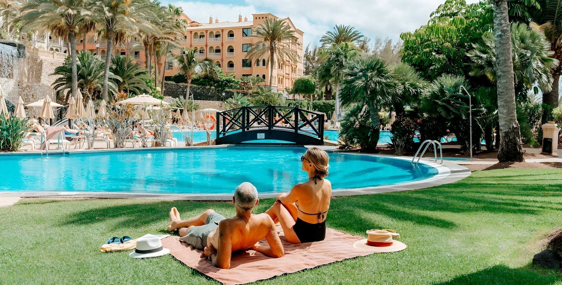 une piscine entourée de chaises et de parasols avec vue sur l'océan
