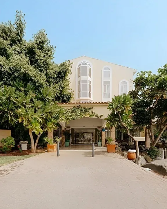 Eingang zum R2 Buganvilla Hotel & Spa mit üppigem Grün und einladender Architektur.