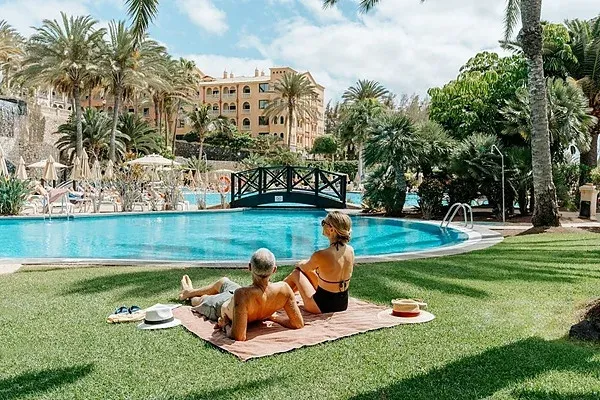Paar entspannt sich im R2 Hoteles: Corporativa am Pool.