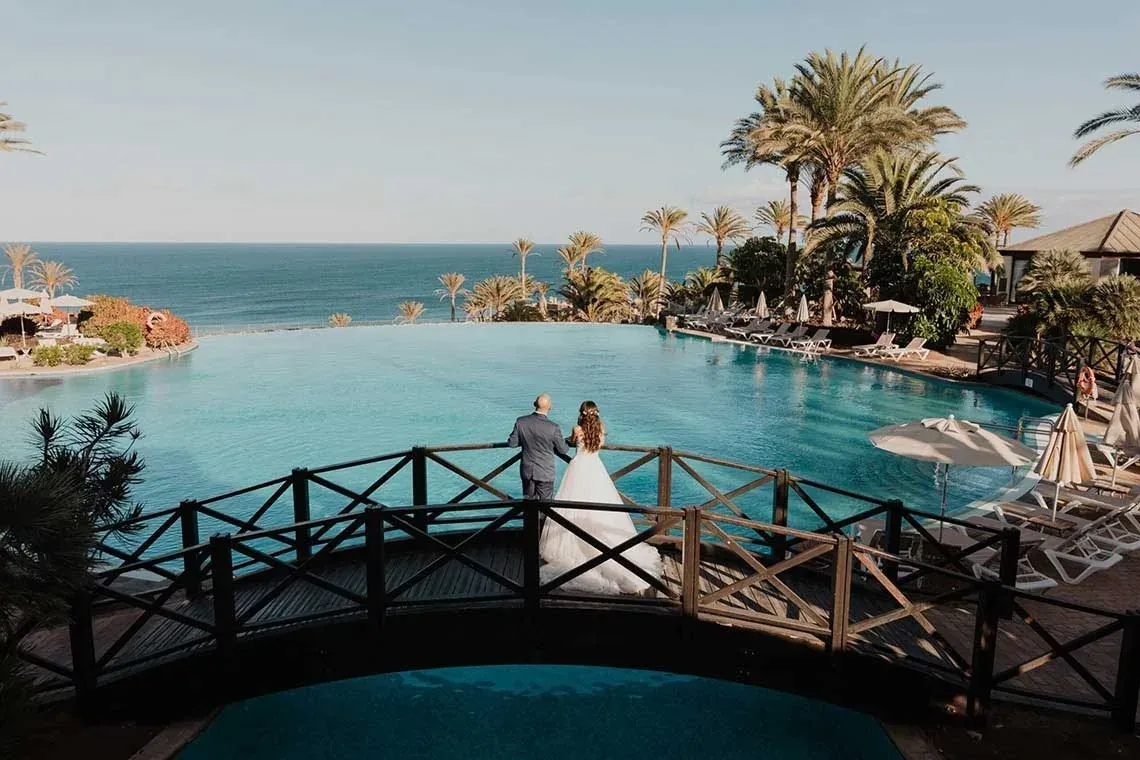 Novios en puente con vista al mar en R2 Hoteles: Corporativa. Paraíso tropical.